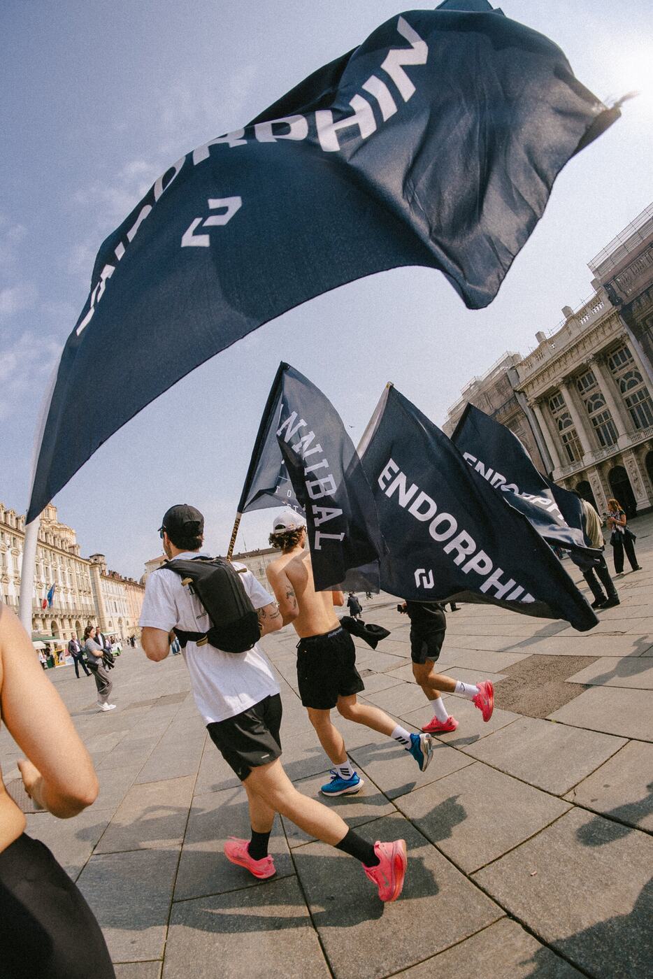 Una grande bandiera ENDORPHIN sventola sopra i runner in piazza