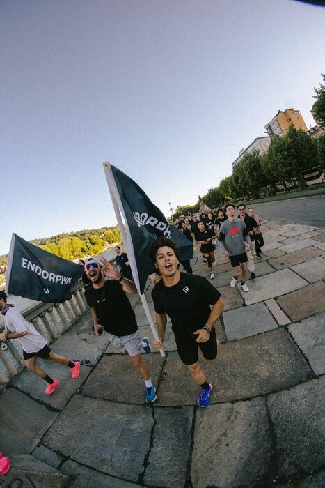Runner con la bandiera ENDORPHIN corrono lungo il viale del parco